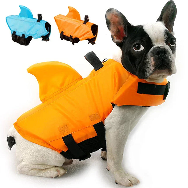 Dog wearing an orange shark fin life jacket, adjustable straps, convenient handle, durable material.