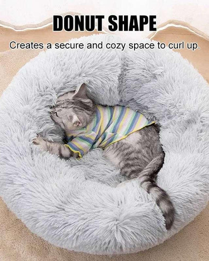 Fluffy grey pet bed with sleeping cat, showcasing donut shape design for comfort.